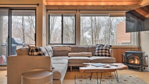 Ein gemütliches Wohnzimmer mit einer Eckcouch, einem runden Couchtisch und einem Kamin.