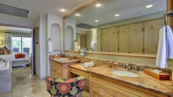 Un baño con un espejo grande, dos lavamanos y armarios de madera.