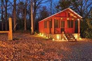 A small, single-story wooden cabin with a porch, surrounded by trees and covered in fallen leaves. - Bungo Creek Retreat w/ Multi-use Trails & a Creek (Pine River)
