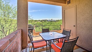 A balcony with a table and chairs, a grill, and a view of a green landscape. - Relaxing Green Valley Townhome ~ 30 Mi to Tucson! (Green Valley)
