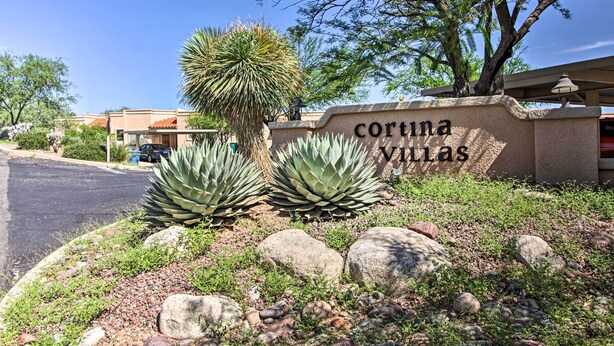 A sign for 'Cortina Villas' with a landscaped area featuring agave plants and rocks. - Relaxing Green Valley Townhome ~ 30 Mi to Tucson! (Green Valley)