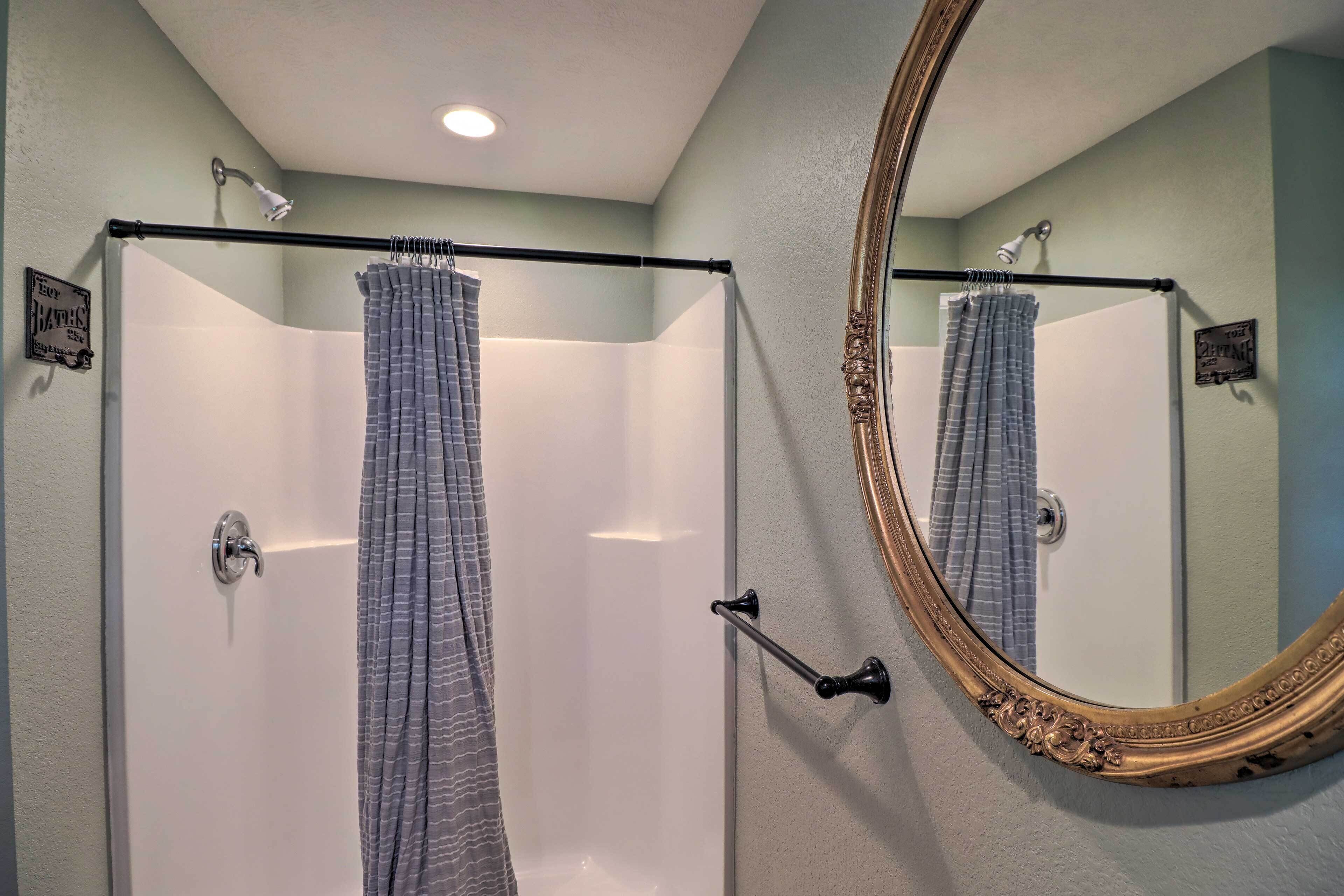 Ein Badezimmer mit Dusche, Badewanne und einem großen Spiegel.