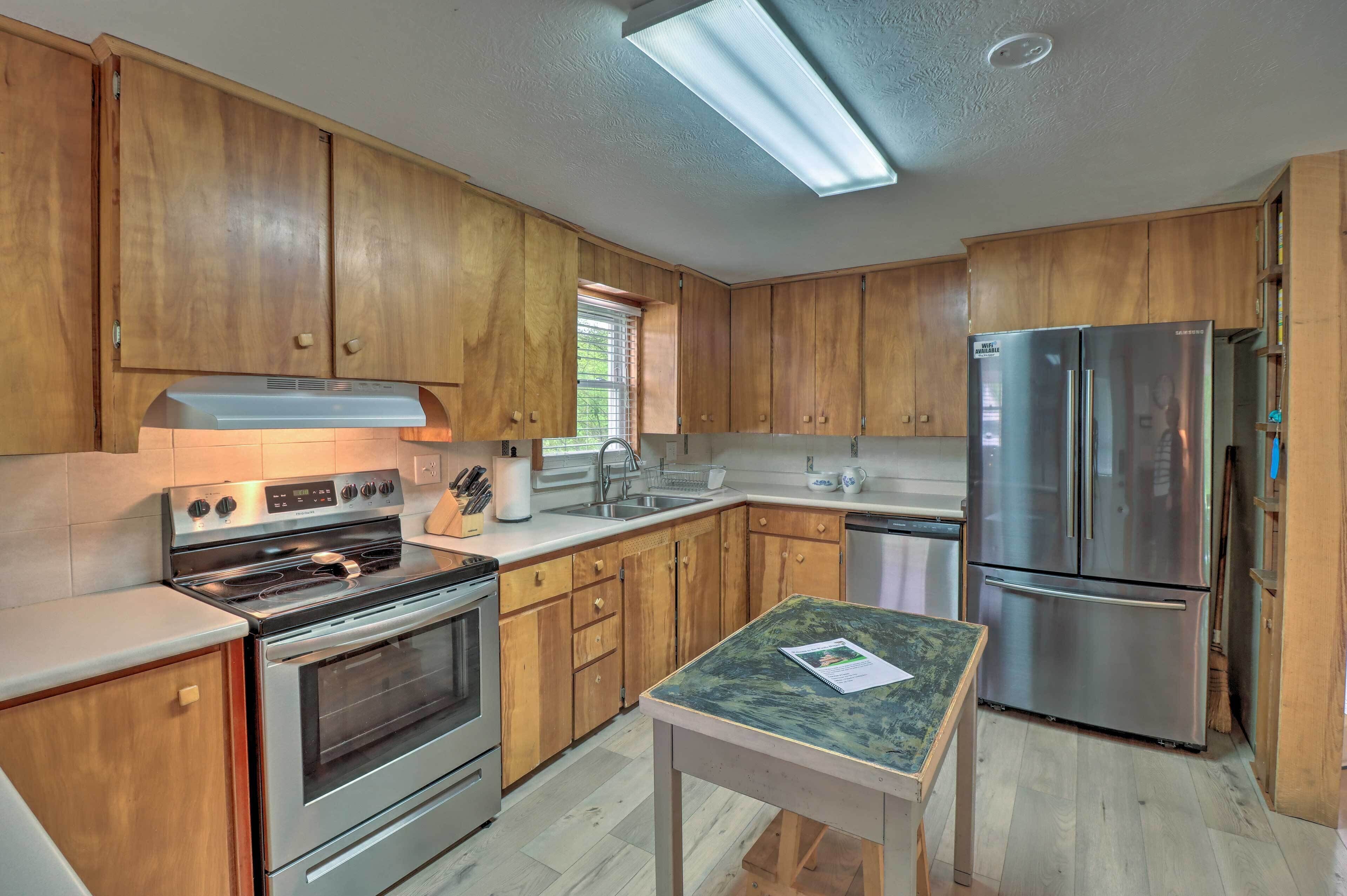 A kitchen with wooden cabinets, stainless steel appliances, a window, and a table with a placemat.