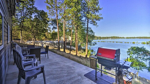 An outdoor patio with a grill, chairs, and a view of a lake. - Hidden Gem: Dock & Views on Pine Hollow Reservoir! (Tygh Valley)