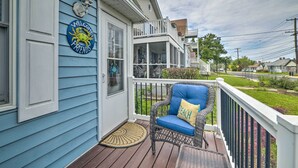 A porch with a wicker chair and a welcome sign.