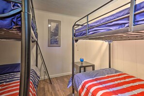 Une chambre avec un lit superposé, une petite table et un globe terrestre.