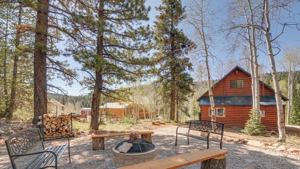 A rustic cabin with a fire pit and benches in a forested area. - Near Natl Parks! Secluded Duck Creek Village Gem (Duck Creek Village)