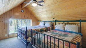 A bedroom with two beds, a ceiling fan, wooden walls, and a window. - Near Natl Parks! Secluded Duck Creek Village Gem (Duck Creek Village)