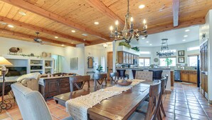 A spacious kitchen with wooden cabinets, a central island, and a dining area with a long table and chairs. - Private Pool, Spa, & Grills: Lake Havasu City Home (Lake Havasu City)