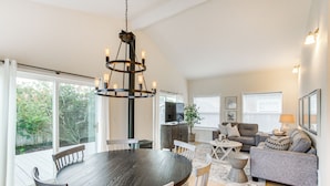 A spacious living area with a dining table, sofas, and a chandelier. - Steps to Beach! Airy Coastal Escape w/ Deck (Pacific Beach)