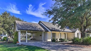 A single-story house with a covered porch, a stone exterior, and a well-maintained lawn. - Downtown Boerne Home on Cibolo Creek w/ Fire Pit (Boerne)