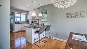 A modern kitchen with a central island, pendant lights, and a decorative ceiling piece. - Lakefront Family Retreat w/ Grill: Steps to Beach! (Gary)