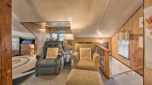 Un salon chaleureux avec une cheminée, un canapé, un fauteuil et une table basse.