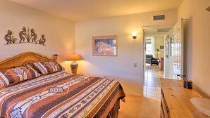 A bedroom with a bed, a nightstand, a lamp, a framed picture on the wall, and a wooden dresser. - Sun-soaked AZ Townhome w/ Private Patio & Mtn View (Green Valley)
