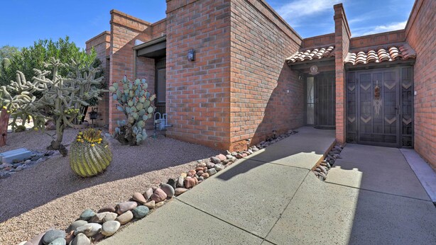 A brick building with a patio, a cactus garden, and a gated entrance. - Sun-soaked AZ Townhome w/ Private Patio & Mtn View (Green Valley)