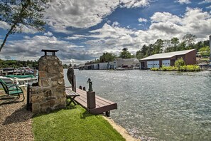 A riverside dock with a stone structure, a wooden pier, and a boat dock. - Weirs Channel Cottage w/ Beach Access! (Laconia)
