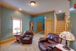 A living room with two leather sofas, a wooden staircase, and a stained glass lamp. - Hot Tub & Private Pond! Spacious Mcarthur Home (McArthur)