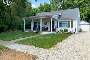 A single-story house with a covered porch, a garage, and a well-maintained lawn.