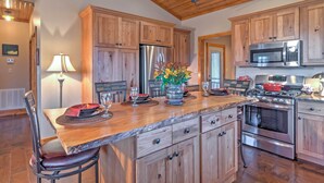 A kitchen with wooden cabinets, a stainless steel refrigerator, a microwave, and a stove. - Beautiful Makanda Cabin in Shawnee National Forest (Makanda)