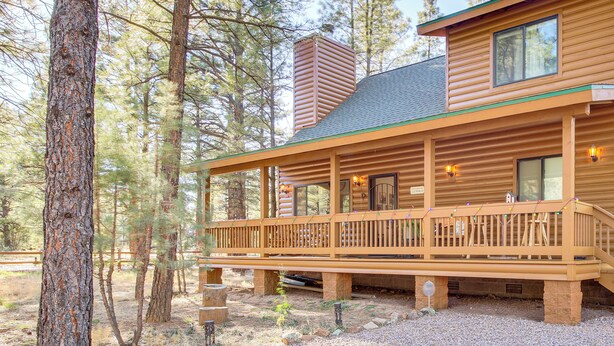 A wooden cabin with a deck, surrounded by trees. - 2 Mi to Fool Hollow Lake: Wooded Cabin w/ Fire Pit (Show Low)