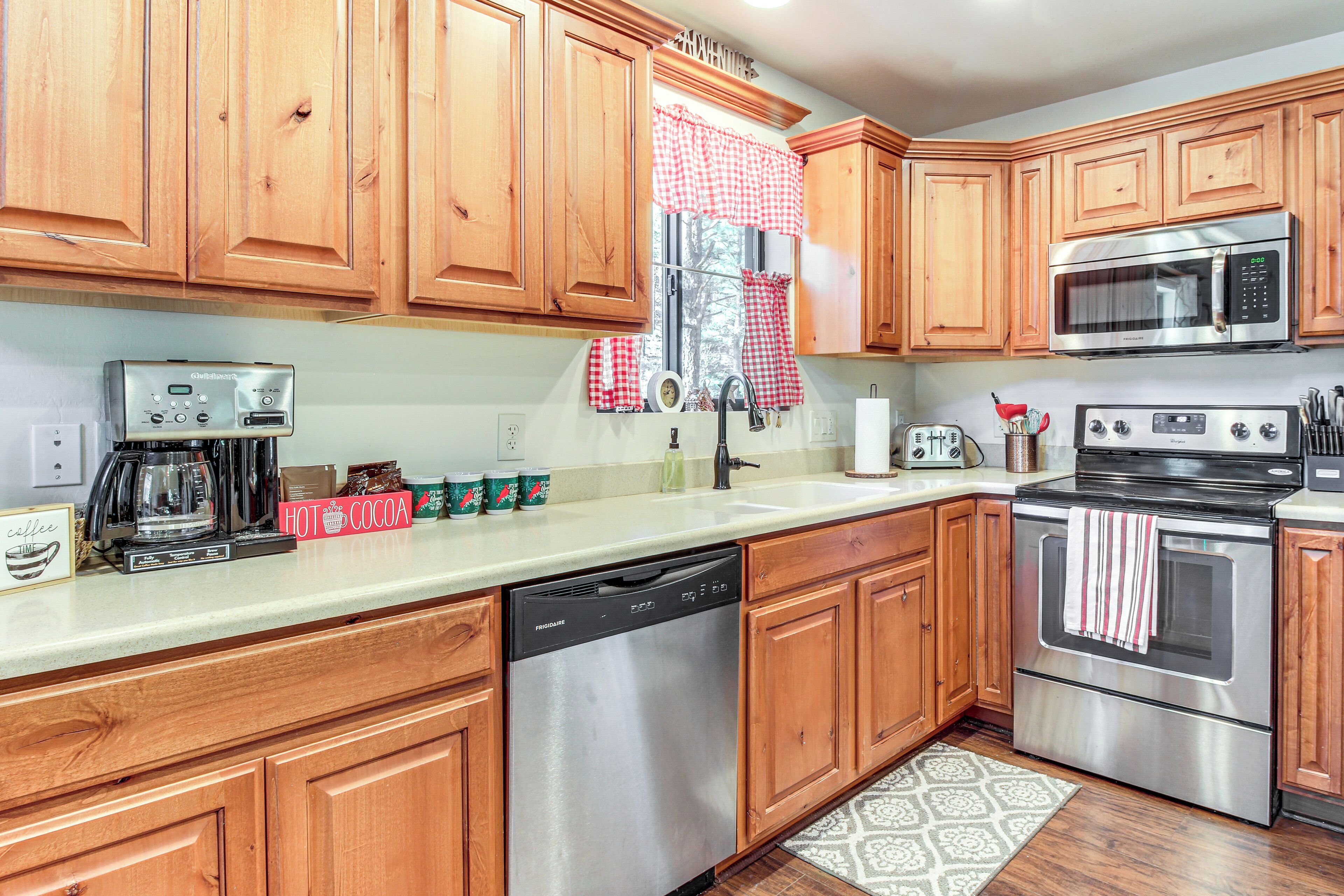 A kitchen with wooden cabinets, stainless steel appliances, a coffee maker, and a dishwashing unit.