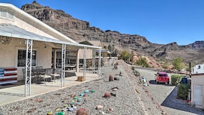 A building with outdoor seating, a covered patio, and a view of a mountainous landscape. - Sun-dappled AZ Abode w/ River & Mtn Views! (Parker)