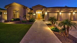 A two-story house with a well-lit driveway, palm trees, and a clear sky. - Patio, Playground! Glendale Family Gem Near Golf (Glendale)