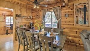 A wooden cabin interior with a dining area, a kitchen, and a staircase. - Large Deck, Grill: Pet-friendly Show Low Retreat! (Show Low)