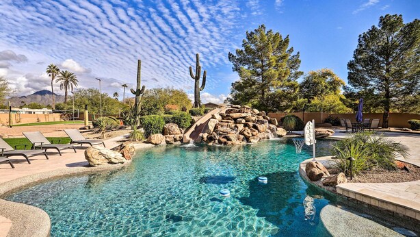 A clear pool with rocks and cacti, surrounded by lounge chairs and a mountain in the background. - Lavish Estate w/ Sports Court & Home Theater! (Scottsdale)
