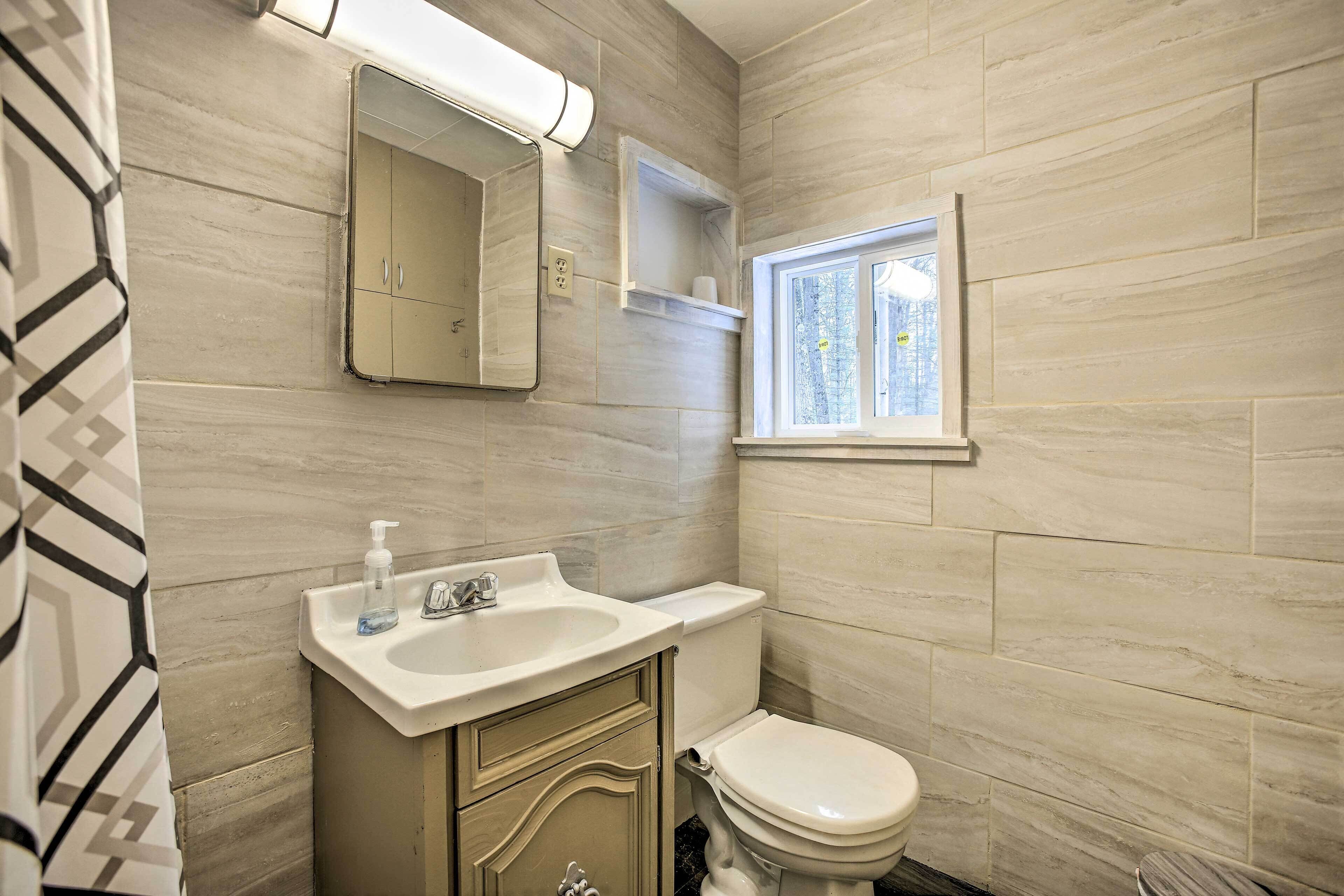 Un baño con lavabo, espejo e inodoro.