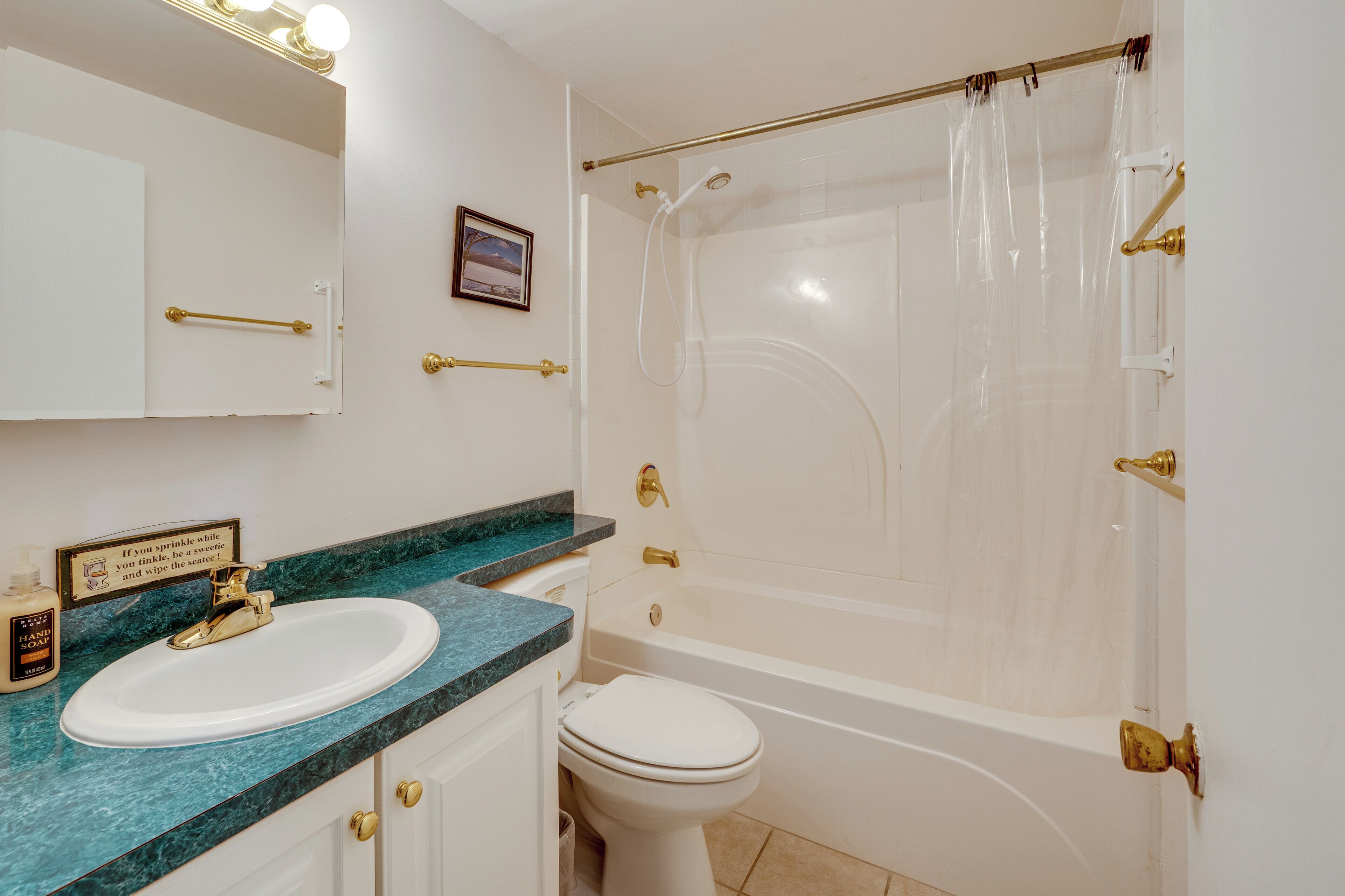 A bathroom with a white sink, a bathtub, and a shower curtain.