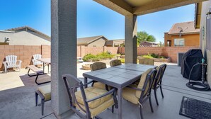 An outdoor patio with a table and chairs, a grill, and a hose. - Step-free Sahuarita Retreat! Patio + Pool Access (Sahuarita)