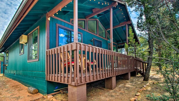 A wooden cabin with a deck, large windows, and a dirt ground. - Near Hiking: Modern Heber-overgaard Cabin w/ Deck (Overgaard)