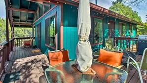 A covered outdoor seating area with a table, chairs, and an umbrella. - Near Hiking: Modern Heber-overgaard Cabin w/ Deck (Overgaard)
