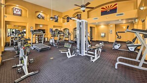 Une salle de sport équipée de divers appareils d’exercice, notamment des tapis de course, des vélos d’appartement et des appareils de musculation.