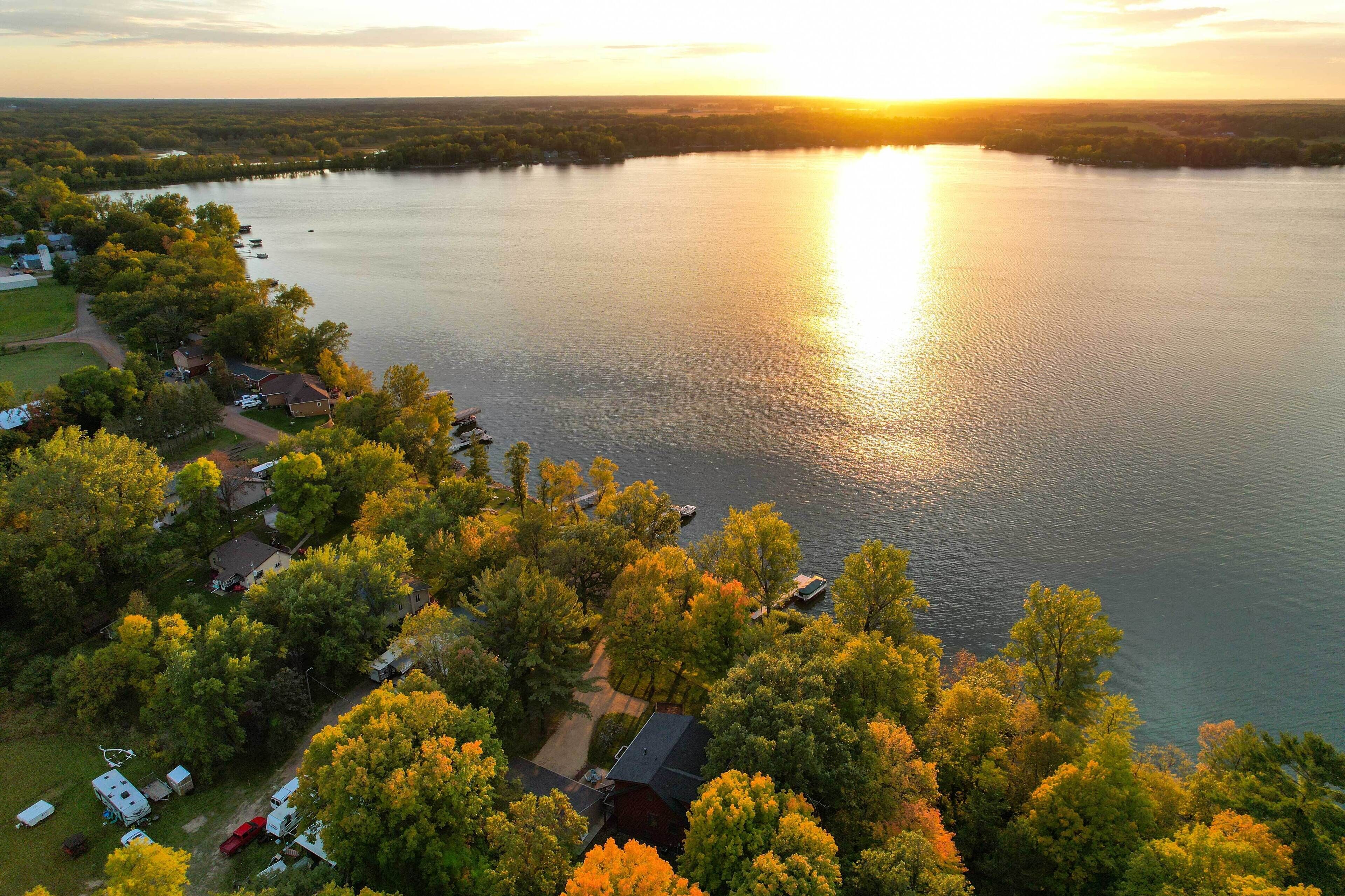 An aerial view of a lakeside property with cabins and a boat dock.