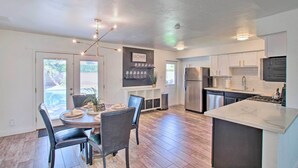 A modern kitchen with a central island, built-in appliances, and a dining area with a round table and chairs.