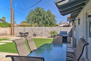 A patio with a table and chairs, a grill, and a small garden area. - Stylish Scottsdale Oasis Close to Old Town! (Scottsdale)