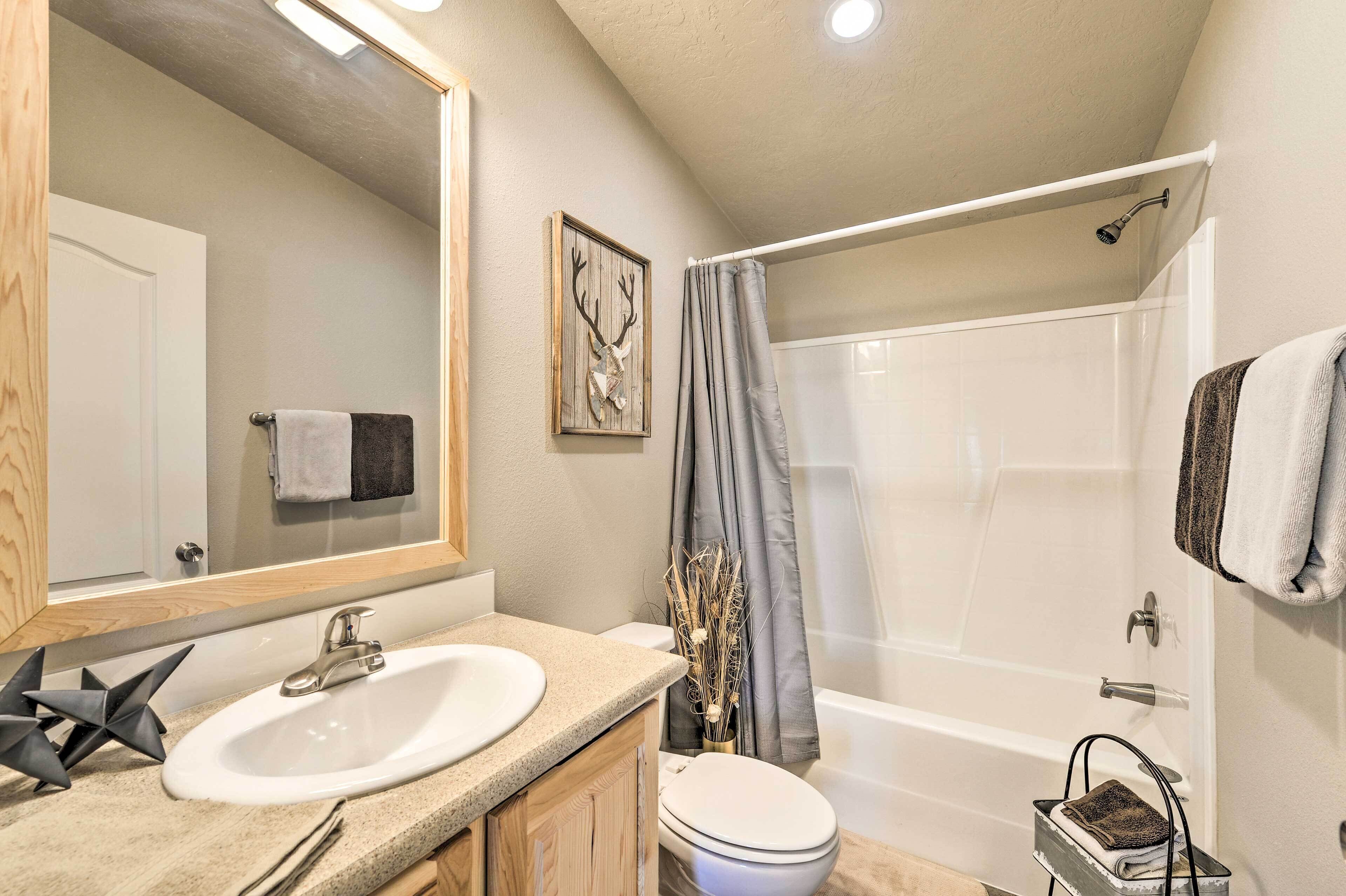 A bathroom with a sink, toilet, and shower.