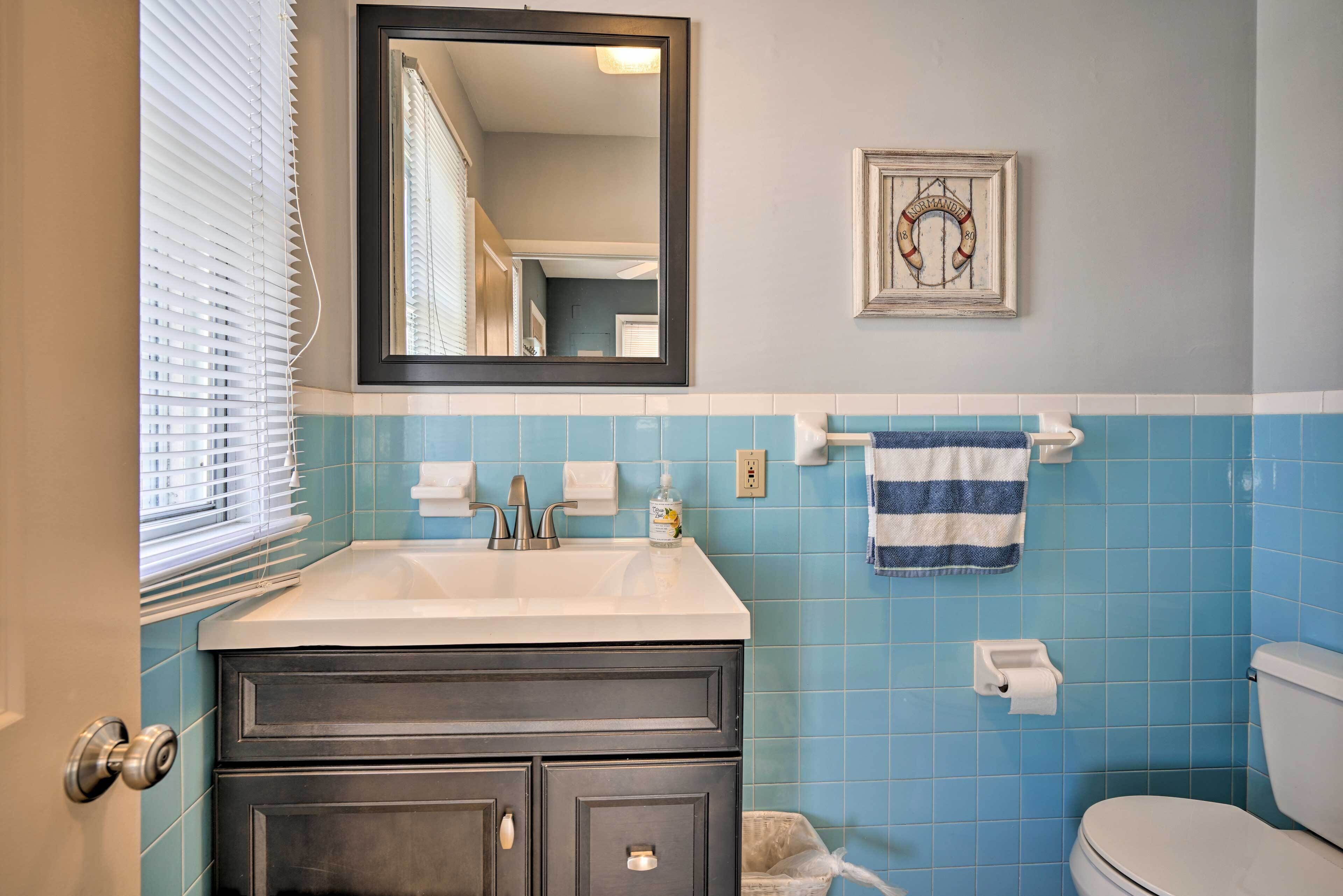 Une salle de bain équipée d’un lavabo, d’un miroir, d’un porte-serviettes et de toilettes.
