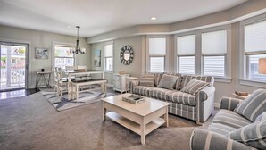 A spacious living room with a sofa, coffee table, and dining area. - Charming Ocean City Townhome: Walk to Beach! (Ocean City)
