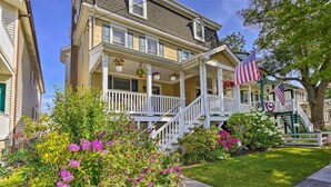 A two-story house with a porch, a staircase, and an American flag. - Charming Ocean City Townhome: Walk to Beach! (Ocean City)