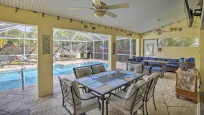 Ein Wintergarten mit Pool, Sitzgelegenheiten im Freien und Deckenventilator.