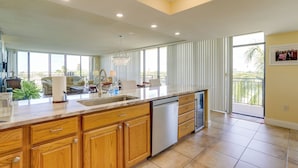 A spacious kitchen with a large island, wooden cabinets, and a dishwasher.