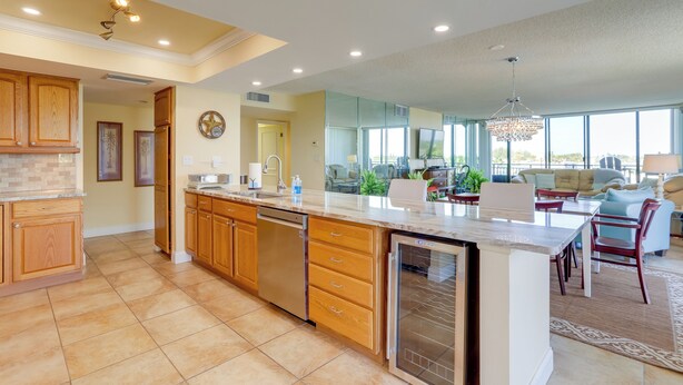 A spacious kitchen with wooden cabinets, a dishwasher, and a large island.