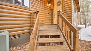A wooden cabin with a wooden staircase leading to a door with a wreath. - Deck & Game Room: Spacious Pinetop Cabin! (Pinetop)