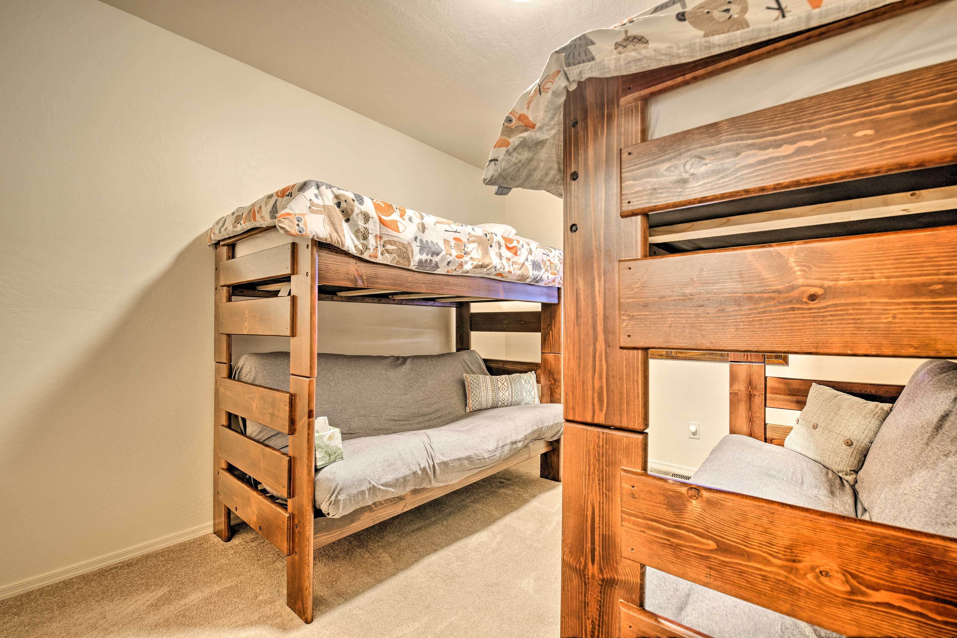 Una cama litera con estructura de madera y manta estampada.