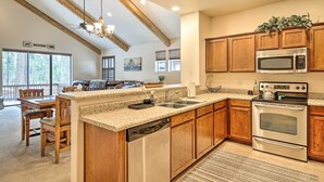 A kitchen with wooden cabinets, a stainless steel microwave, and a dishwasher. - Deck & Game Room: Spacious Pinetop Cabin! (Pinetop)