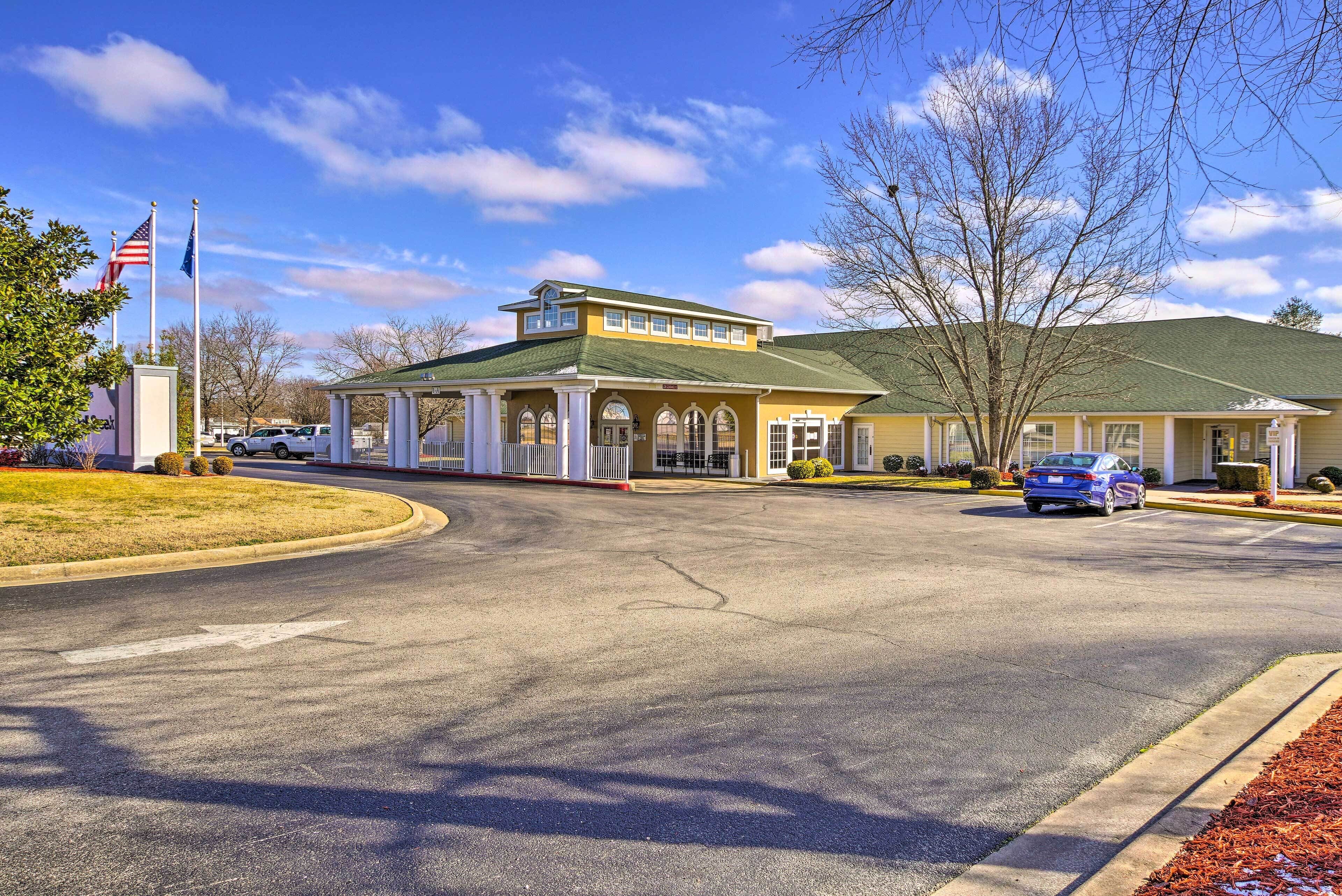 A two-story building with a green roof and a covered entrance area.