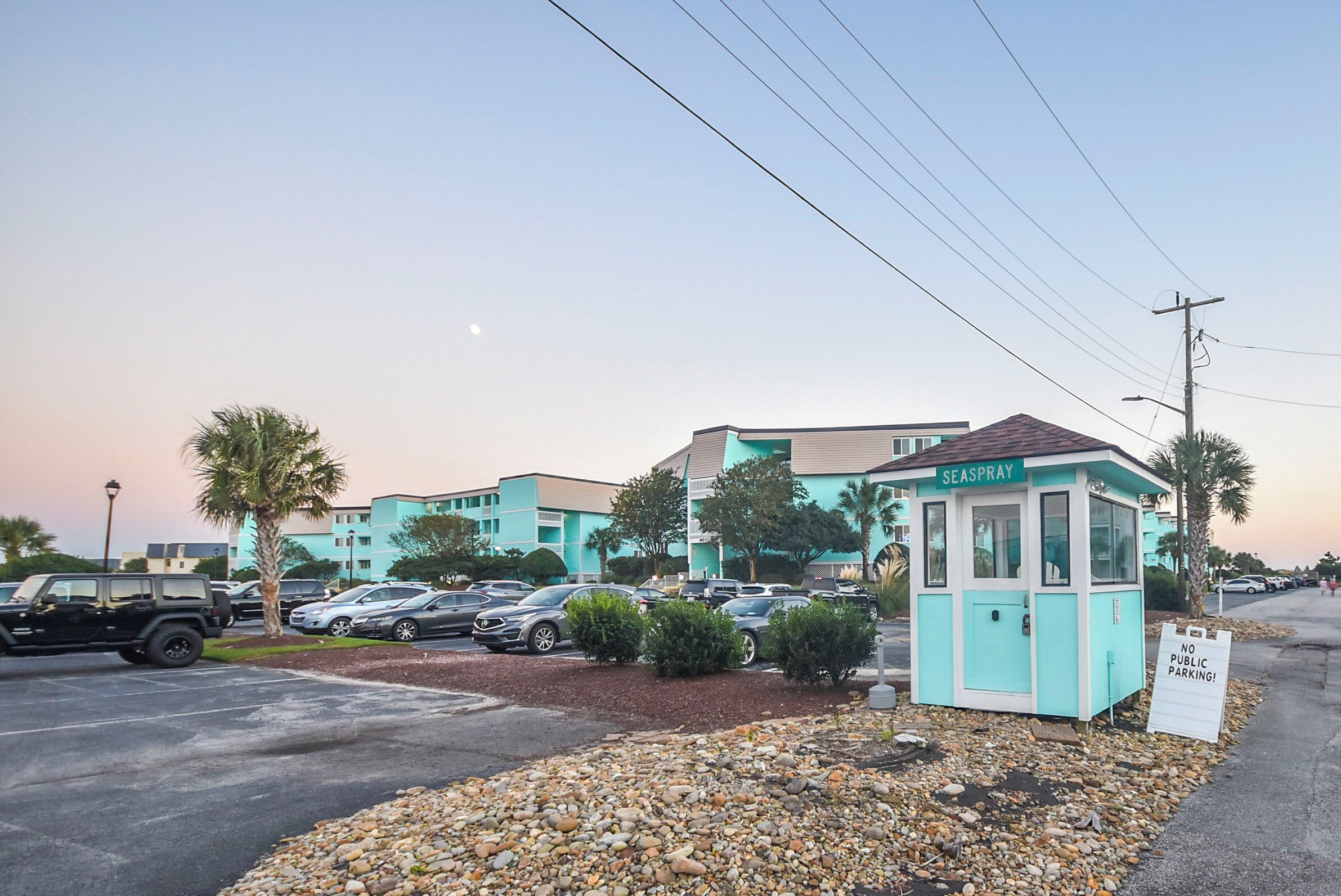 A parking area with a small kiosk labeled "SEASPRAY" and a sign indicating "NO PUBLIC PARKING."